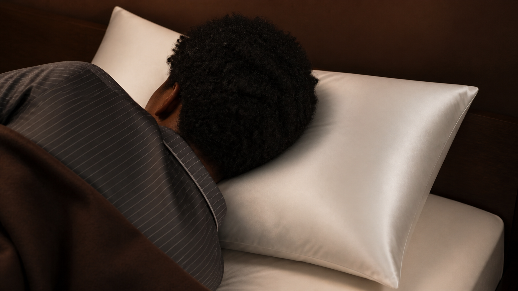 Curly hair resting on a white silk pillowcase
